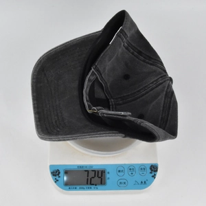 Detailed shot of a vintage washed cotton baseball cap being weighed on a digital scale