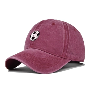 Macro detail of the vintage washed fabric and soccer embroidery on the burgundy baseball cap