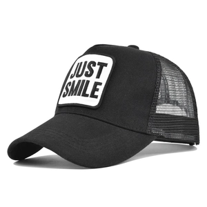 Detail of breathable mesh trucker hat with Just Smile embroidery on a black cap