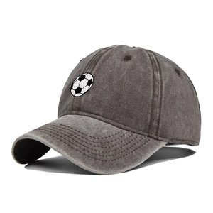 Close-up of washed charcoal grey baseball cap with embroidered football pattern on front