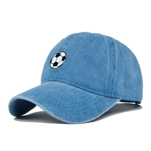Close-up of a blue washed denim baseball cap with an embroidered soccer ball logo