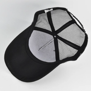 Detail view of the black trucker hat interior with breathable mesh and adjustable strap