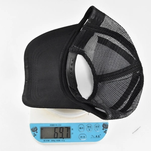 Close-up of lightweight black mesh baseball cap weighing 69.7g on electronic scale