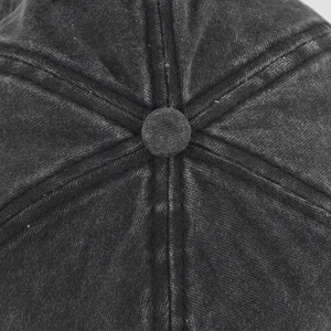 Macro shot of the top button and stitched seams on the washed grey cotton baseball cap