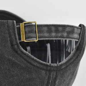 Detail of adjustable metal brass buckle on vintage washed cotton baseball cap strap