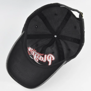 Detailed interior of black baseball cap with red embroidery and metal buckle strap