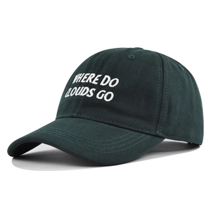 Detail of white embroidery text on dark green cotton twill baseball cap fabric