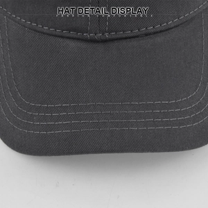 Close-up of brim stitching and twill cotton texture on a dark grey baseball cap