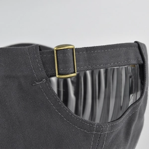 Detailed macro view of the dark grey cotton baseball cap with antique brass buckle adjuster