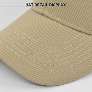 Detail shot of khaki baseball cap brim featuring neat parallel white stitching texture