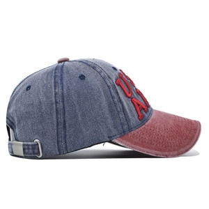 Detail of blue denim baseball cap featuring red 3D USA embroidery and stitch texture