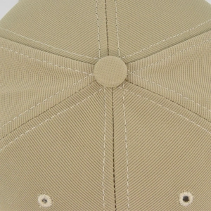 Close-up of khaki baseball cap crown with fabric button and metal ventilation eyelets