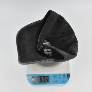 Vue détaillée d'une casquette vintage lavée pesant 80,5g sur une balance numérique