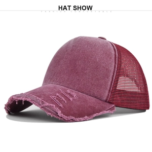 Detail of vintage washed burgundy trucker hat featuring distressed brim and mesh back