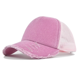 Detailed side view of vintage pink trucker hat with distressed brim and breathable mesh back