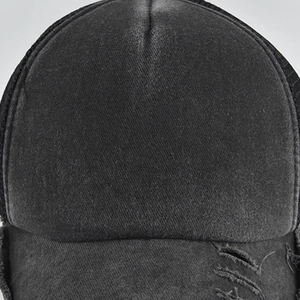 Close-up of distressed brim details on a washed gray mesh back baseball trucker hat