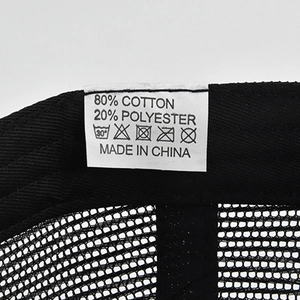Detail view of cotton and polyester care label inside the breathable black mesh trucker cap