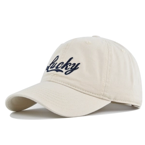 Detail der marineblauen Lucky-Stickerei auf einer cremefarbenen Baumwoll-Baseballkappe für Damen