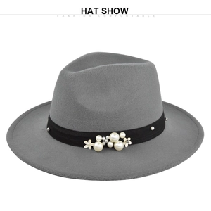 Detail of grey wool fedora hat featuring black ribbon with pearls and flower accents