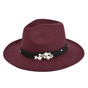 Detail of burgundy wool fedora featuring black ribbon with pearls and metal flower accents