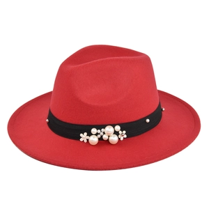 Detail of red wool fedora hat featuring black ribbon with pearls and small white flowers