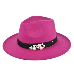 Detail of rose red fedora hat with elegant black band, white pearls and floral accents