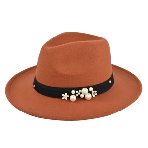 Detail of rust red felt fedora hat featuring black band with pearl and floral accents