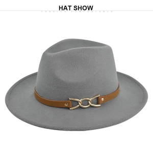 Detail of grey wide brim fedora hat featuring brown leather band and gold chain link