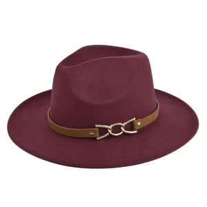 Detail of burgundy wool fedora hat featuring a brown leather band and gold chain buckle