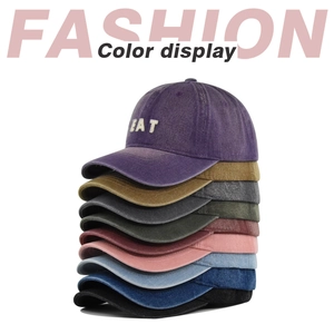 Vertical stack of multi-colored washed denim baseball caps with EAT embroidery detail