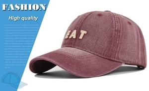 Detailed view of high-quality EAT embroidery on a vintage washed dark red denim baseball cap