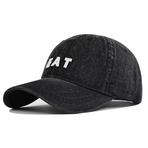 Detailed view of the EAT white 3D embroidery on a black washed denim baseball cap