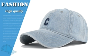 Detailed close-up of light blue denim baseball cap with vintage 'C' embroidery texture