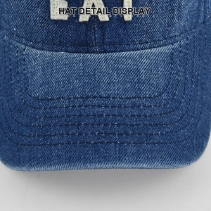 Macro shot of blue denim baseball cap showing detailed embroidery and parallel stitching