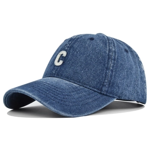 Close-up of vintage washed blue denim baseball cap with white chenille letter C embroidery