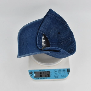 Detailed weight measurement showing the 107.6g vintage washed blue denim baseball cap