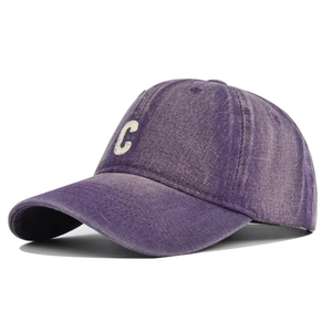 Detailed view of purple washed denim baseball cap with white C embroidery and curved brim