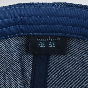 Macro shot of high-quality inner stitching and brand label on a washed denim baseball cap