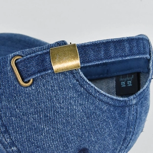 Close-up of vintage denim baseball cap with adjustable bronze metal buckle and neat stitching