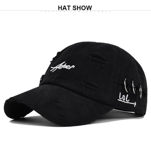 Close-up of distressed black cotton baseball cap with Fisher embroidery and silver rings