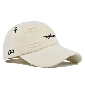 Detailed macro view of distressed off-white cotton baseball cap with Asher embroidery