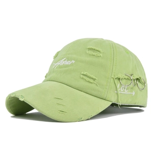 Detail of distressed light green Asher baseball cap with white embroidery and silver rings