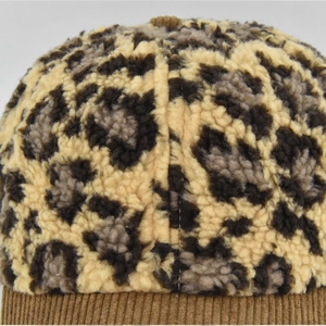 Detail of faux fur leopard print and brown corduroy stitching on warm baseball cap