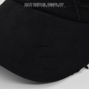 Detailed macro view of distressed ripped details on the brim of a black cotton baseball cap