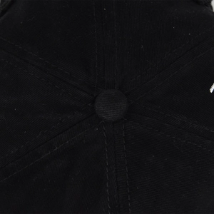Macro detail of the top button and stitched seams on a black cotton Asher baseball cap