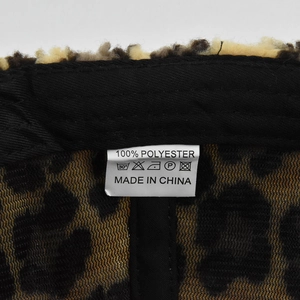 Detail shot of the interior lining and 100% polyester material label of leopard baseball cap