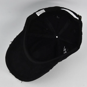 Internal view of a washed cotton baseball cap with a fabric care label and metal strap buckle
