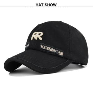 Close-up of RR embroidery and distressed patch detail on black cotton baseball cap