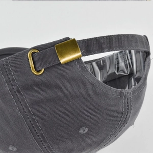Detail of adjustable metal buckle and 100% cotton fabric on the dark grey baseball cap