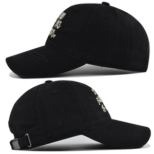 Detailed close-up showing distressed brim and gothic cross embroidery on black canvas cap